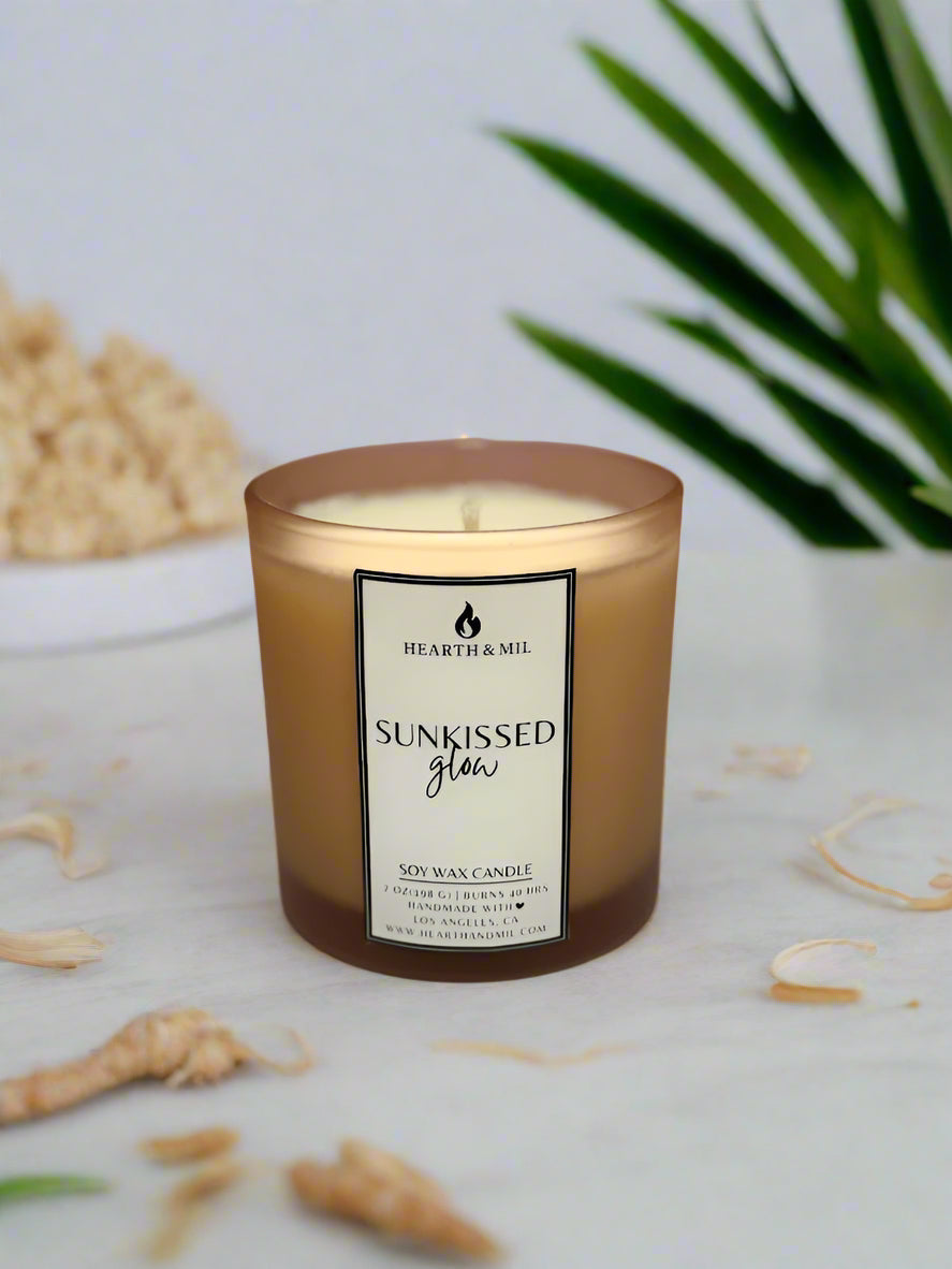 Candle with a label on a white surface and pink background