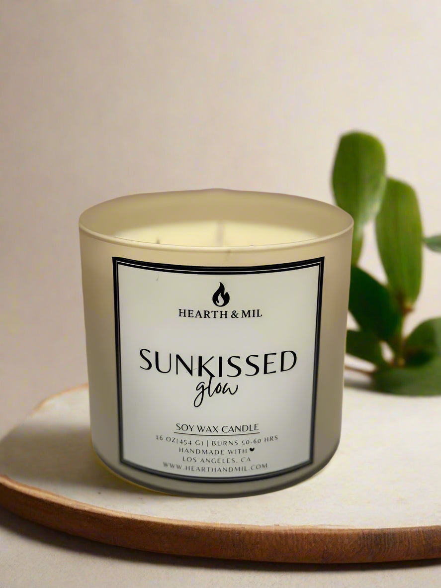 Candle with 'Hearth & Mil' label on a light pink background