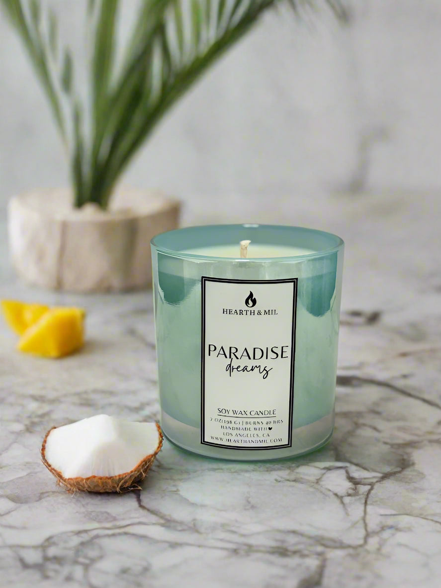 Candle with a label on a marble surface and pink background